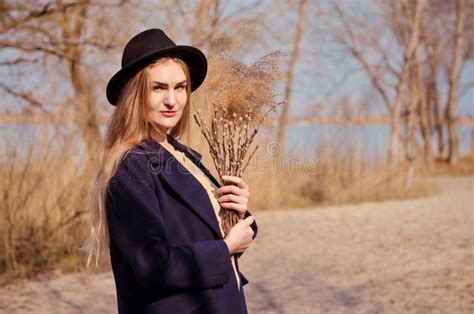 Jeune Fille Blonde Du Caucase Dans Un Manteau Et Un Chapeau De Robe Au Printemps Sur La Plage