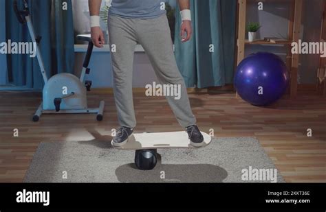 An Unrecognizable Person Trains On The Balance Board In A Home