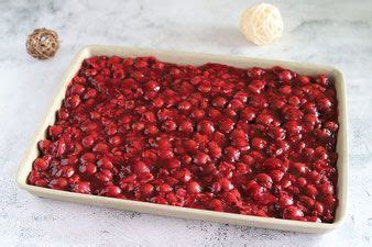 A Pan Filled With Cranberries Sitting On Top Of A Counter Next To Two Balls