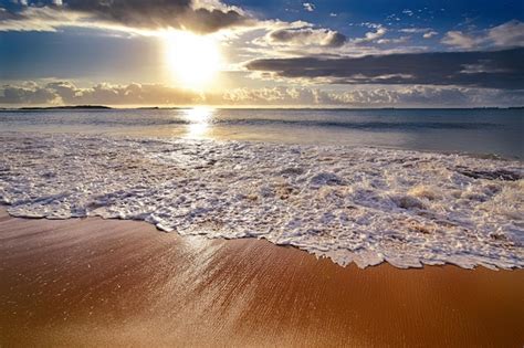 Premium Photo | Ocean waves rolling over the beach during sunrise