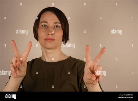 The Petite Woman Stands Confidently With Short Brunette Hair Neatly