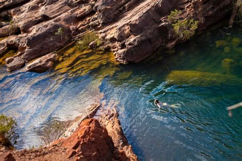 Ein langhaariges Mädchen in einem weißen Bikini nimmt ein erfrischendes Bad in einem