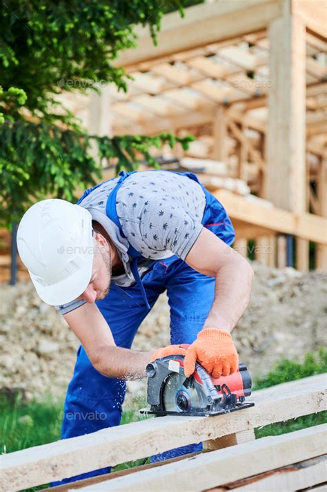 Carpenter Using Circular Saw For Cutting Wooden Plank While Building