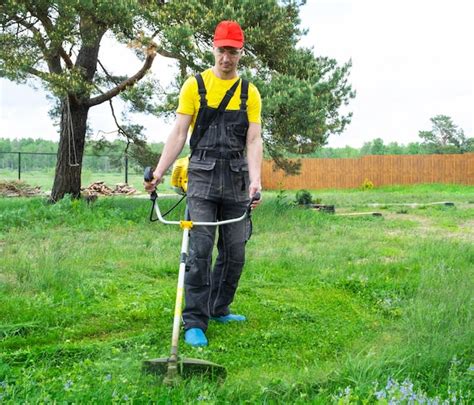 Um Jardineiro Masculino Corta A Grama Verde Do Gramado No Quintal