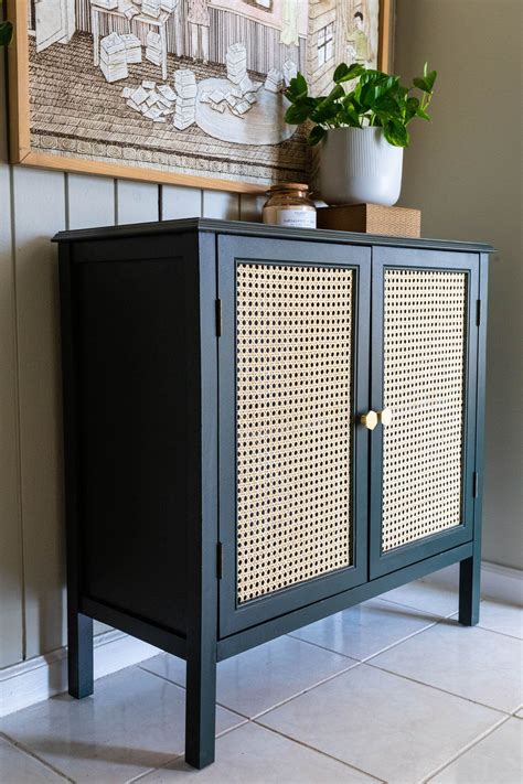 A Black Cabinet With Wicker Doors On The Front And Bottom Next To A