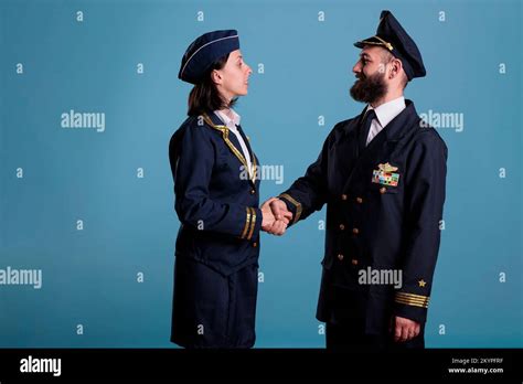 Smiling Airplane Pilot And Flight Attendant Shaking Hands Portrait