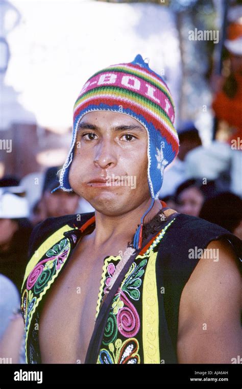 A young Bolivian man in traditional clothes with coca leaves in his mouth during the carnival ...