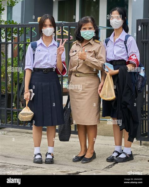 a Thai teacher and her daughters all dressed in their school uniforms Stock Photo - Alamy