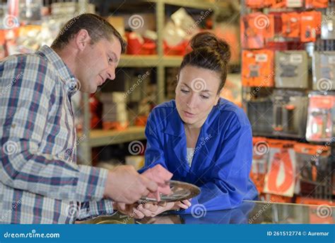 Sales Assistant In Supermarket With Customer During Shopping At Store