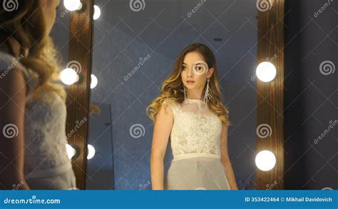 Beautiful Blonde Woman With Long Wavy Hair Wearing An Elegant White Lace Dress Looking At