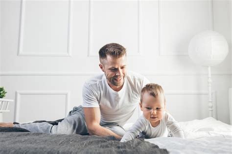 Premium Photo Happy Father With His Son Playing At Home On The Bed