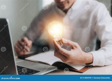 Business Man Holding Light Bulbs And Using Laptop New Ideas With