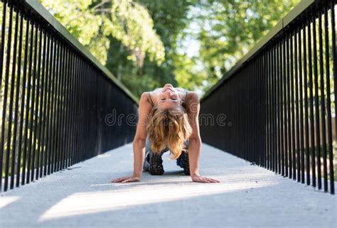 Athletic Pose Of An Attractive 22 Yo Blonde Girl On A Pedestrian Bridge