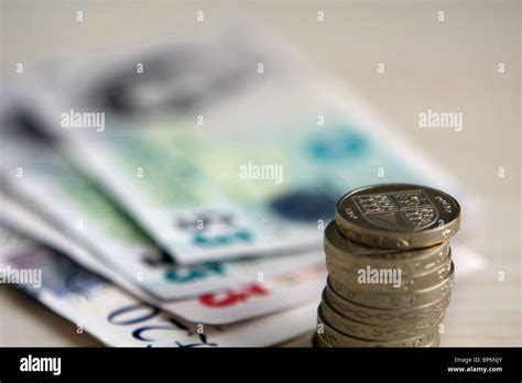 A stack of sterling £1 coins in front of different denomination ...