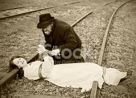 Victorian Vignette Of Villain Tying Maiden TO Railroad Stock Photos