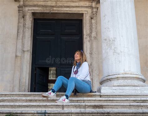 Tourist Woman Looking Away And Smiling While Sitting On Stairs On The