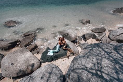 Premium Photo Two Gorgeous Lesbian Mermaids With Long Tails Are Lying On The Rocks And Posing