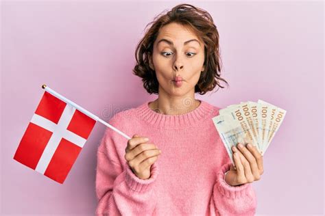 Jeune Brunette Tenant Des Billets De Banquette Norway Et Krone Faisant Le Visage Du Poisson Avec
