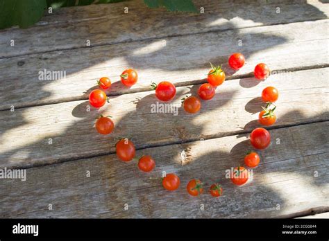 Small Cherry Tomato Tomatoes On A Wooden Background Lined In The Shape