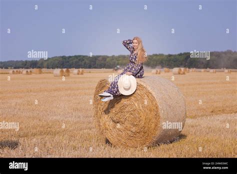 Une Jeune Fille Blonde Aux Cheveux Longs Dans Un Chapeau Blanc Se Repose Et Pose Pr S Des Gerbes