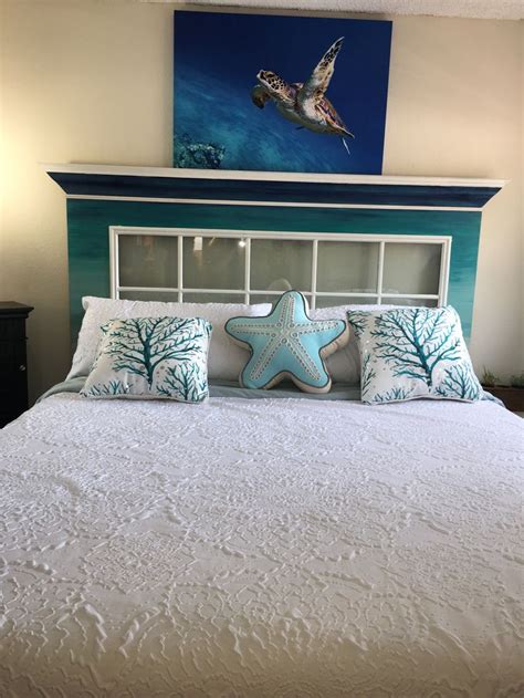 A White Bed Topped With Pillows And A Starfish