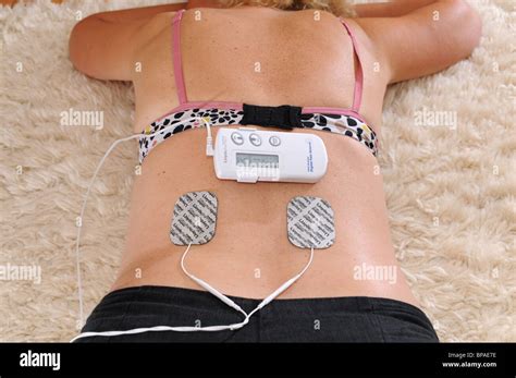 Woman Female Using A Lloyds Pharmacy TENS Digital Pain Reliever To Help