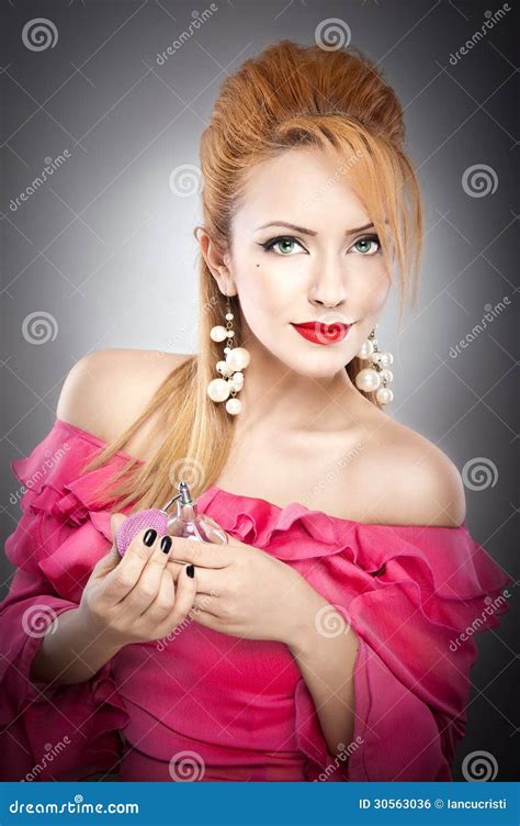Belle Fille Blonde Sexy Heureuse Dans La Robe Rose Avec La Coiffure Et La Bouteille Lumineuse De