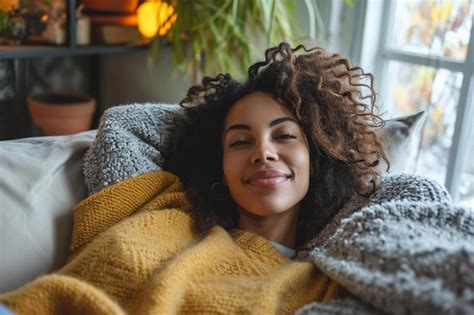 Premium Photo A Woman Laying On A Couch Covered In A Blanket