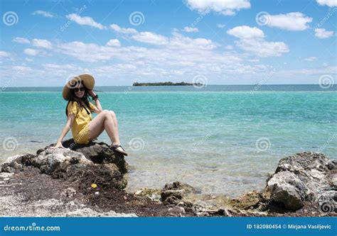 A Woman Sitting on the Rock on the Beach Stock Photo - Image of ocean, vacay: 182080454