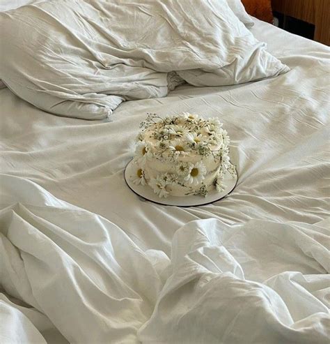 A Cake Sitting On Top Of A Bed Covered In White Sheets