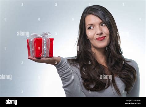 Beautiful Romantic Woman Eying A Red Wrapped Gift Stock Photo Alamy