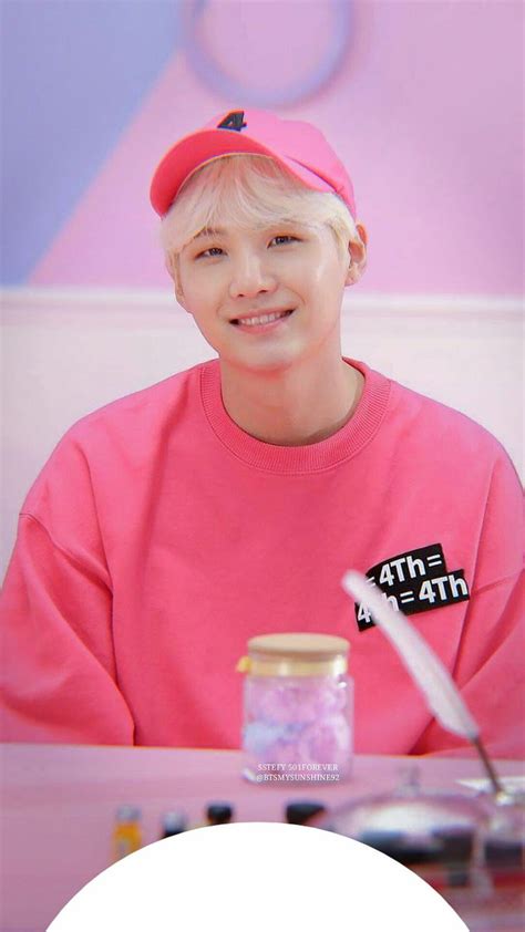 A Person Sitting At A Table Wearing A Pink Shirt And Hat With The Words Btop On It