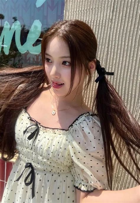 A Woman With Long Hair Standing In Front Of A Building