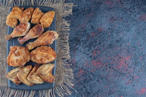 Una Tabla De Madera Oscura Con Carne De Pollo Al Horno Sobre Una Tela