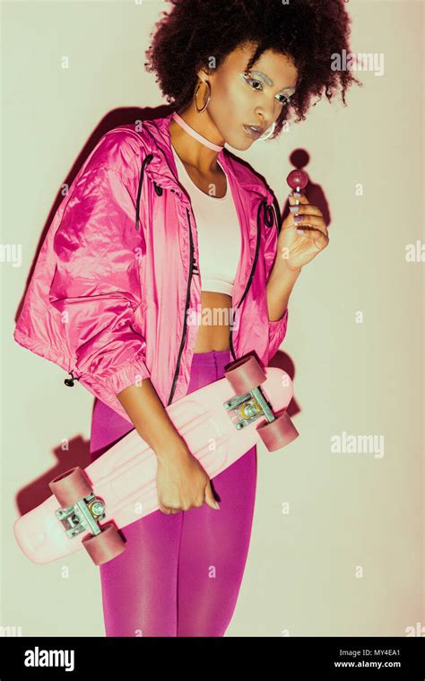 African American 80s Girl In Pink Clothes Posing With Penny Board And