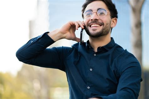 Retrato de hombre joven hablando por teléfono mientras está de pie al