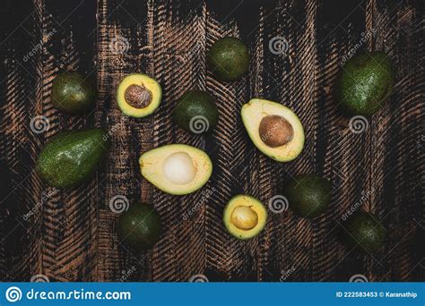 Abacado Inteiro E Dividido Em Metade Sobre Mesa De Madeira Imagem De