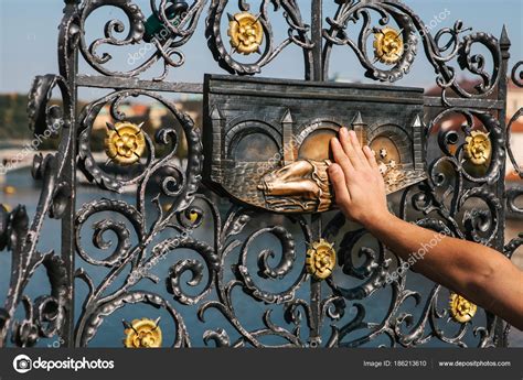 Woman Tourist Touches A Bronze Statue Of John Of Nepomuk On The Charles Bridge In Prague Czech