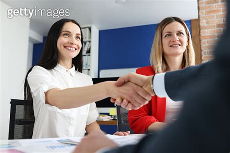 Business partners shake hands at their desk 이미지 1308406290 게티이미지뱅크