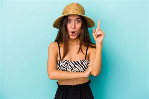 Mujer caucásica joven que va a la playa vistiendo bikini aislado sobre fondo azul con una gran