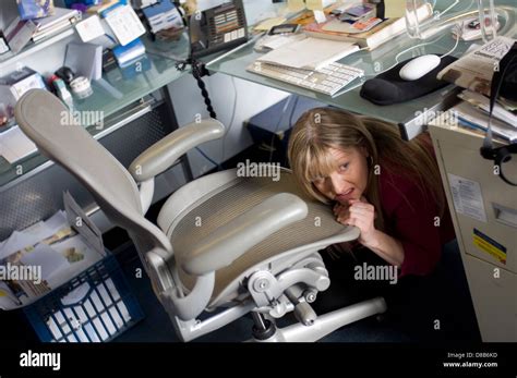 A businesswoman hiding under her desk in her office Stock Photo - Alamy