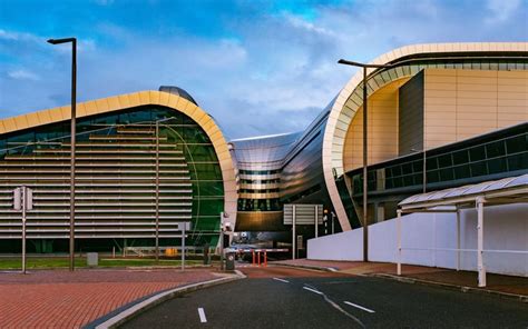 two large curved buildings sitting next to each other on the side of a ...