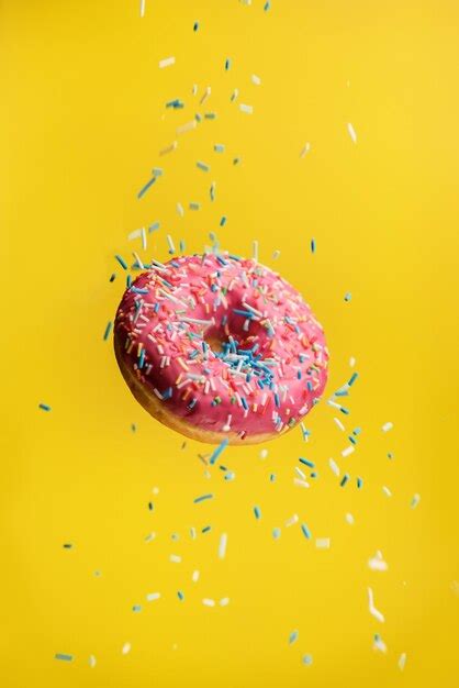 Donut Levitando Sobre Un Fondo Amarillo Con Chispitas Decorativas