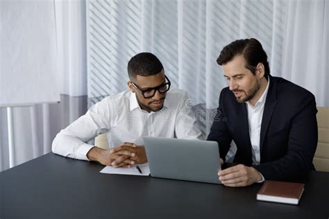 Concentrated Two Diverse Business Partners Working On Computer Stock