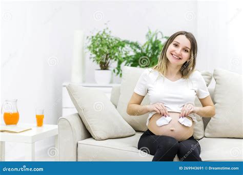 Beautiful Pregnant Woman With Naked Stomach Holding Small Socks Stock