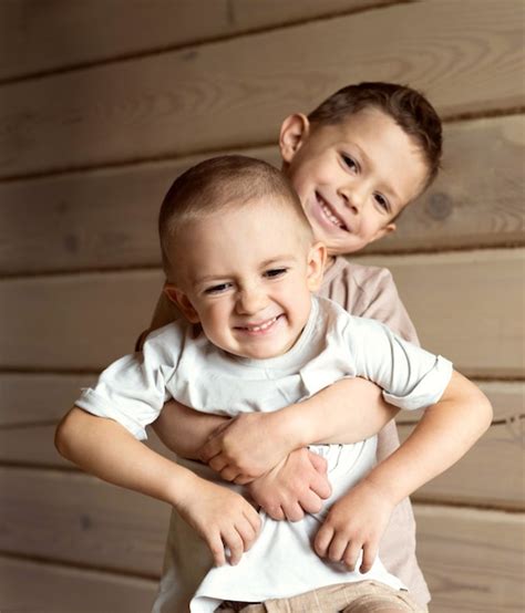 El niño abraza a su hermano pequeño el hermano mayor sostiene al menor