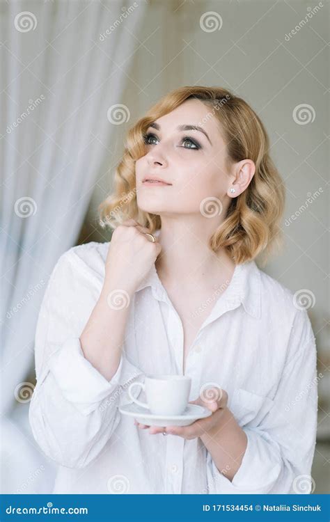 Mooie Jonge Blonde Meid In Een Lichtshirt In Een Heldere Kamer Geniet Van Een Kop Koffie In De