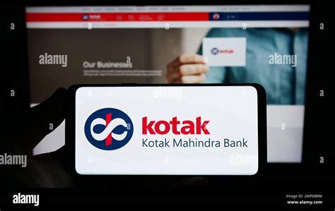 Person Holding Smartphone With Logo Of Indian Financial Company Kotak