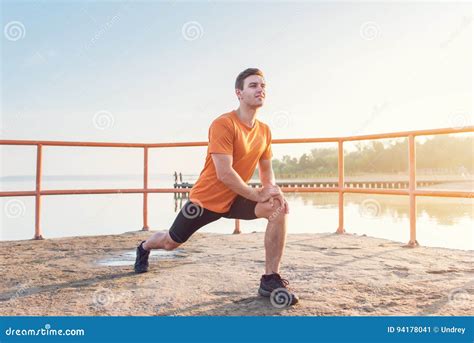 Young Fit Man Stretching Legs Outdoors Doing Forward Lunge Stock Image