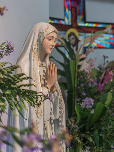 a statue of the virgin mary holding her hands together in front of ...